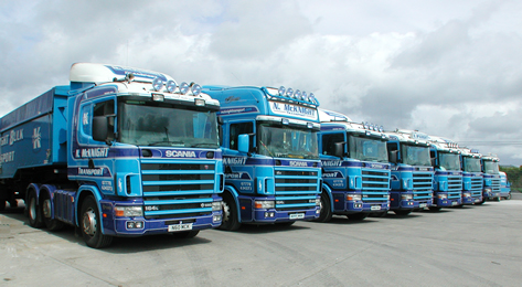 Historic photograph of the older blue McKnight Scania fleet lined up in a yard