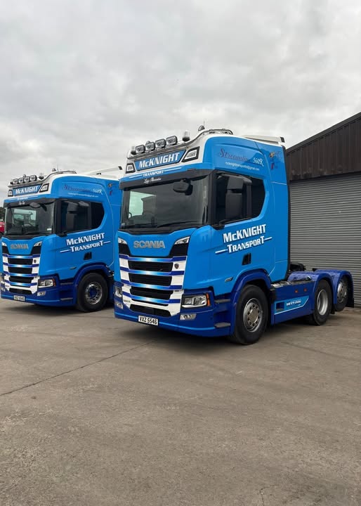 Two blue McKnight Scania 560R tractor units parked together in the yard
