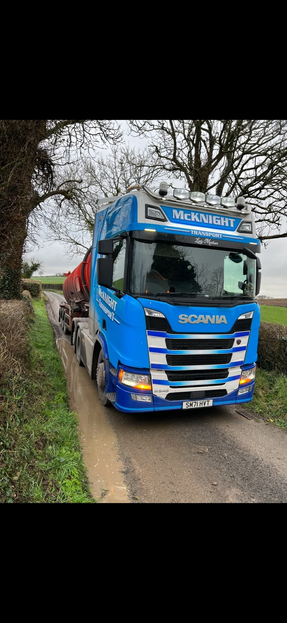 McKnight blue Scania with a red tanker on a narrow country lane