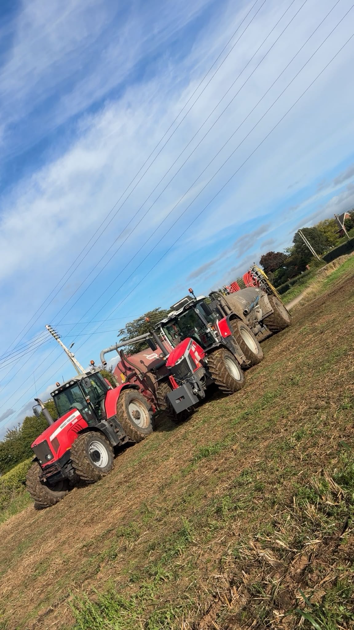 Our Massey Ferguson tractor fleet spreading slurry in a field